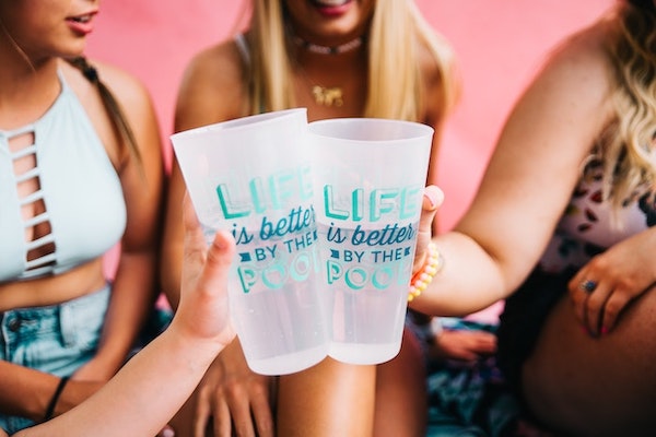 Girls laughing and holding water cups in a cheers